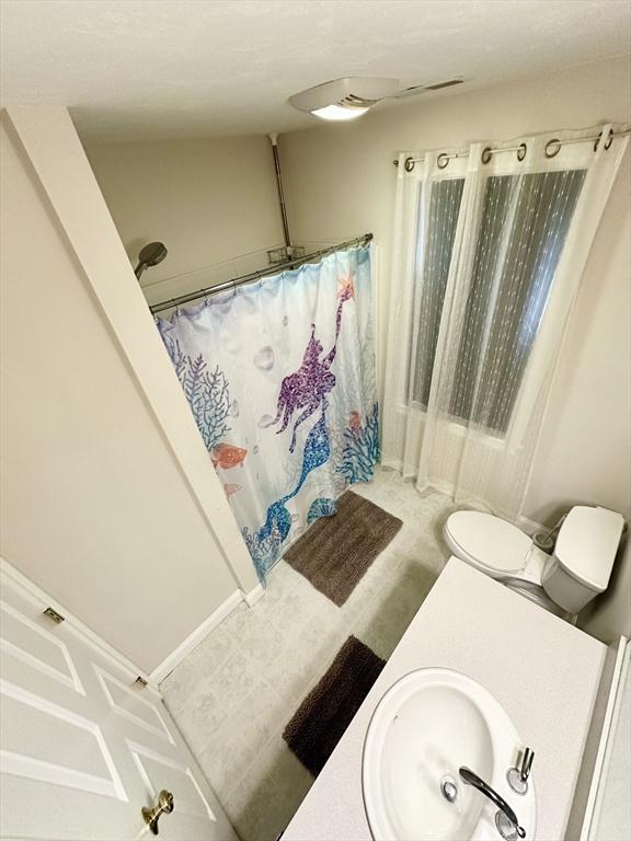 bathroom featuring a shower with shower curtain and a sink