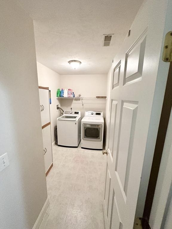 clothes washing area featuring visible vents, independent washer and dryer, a textured ceiling, baseboards, and laundry area