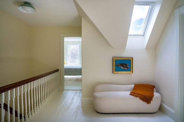sitting room with a skylight and baseboards