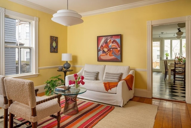 living room with crown molding, baseboards, and wood-type flooring