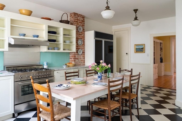 dining room featuring light floors and a wainscoted wall