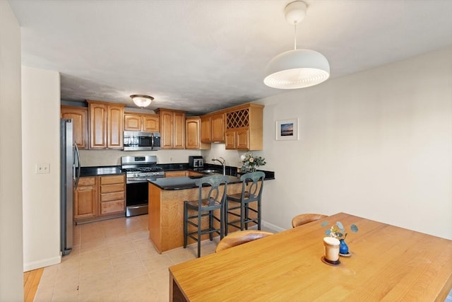 9 Michael Way Unit 41, Andover, MA 01810 - kitchen with appliances with stainless steel finishes, a peninsula, baseboards, dark countertops, and a kitchen bar