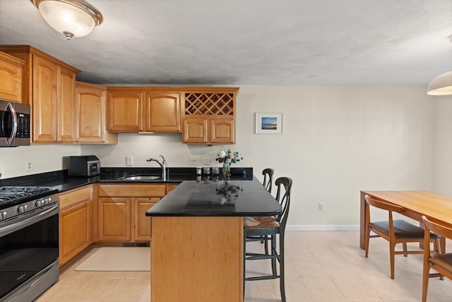 9 Michael Way Unit 41, Andover, MA 01810 - kitchen featuring stainless steel appliances, a breakfast bar area, a sink, dark countertops, and a peninsula