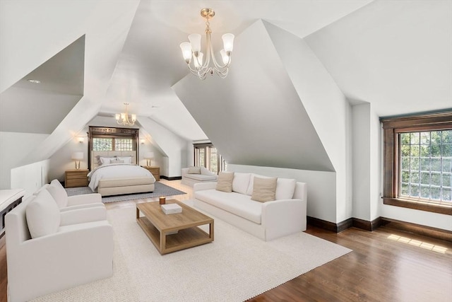 living area with a chandelier, wood finished floors, vaulted ceiling, and baseboards