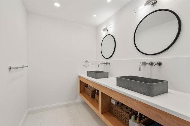 bathroom with recessed lighting, double vanity, baseboards, and tile patterned flooring