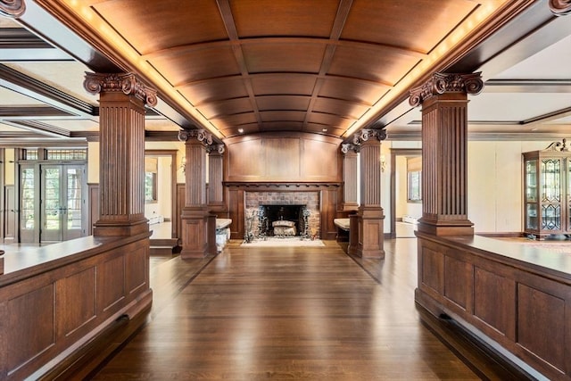 reception area featuring decorative columns, coffered ceiling, a fireplace, french doors, and ornamental molding