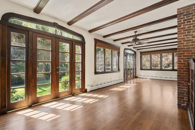 interior space with baseboard heating, beam ceiling, healthy amount of natural light, and wood finished floors
