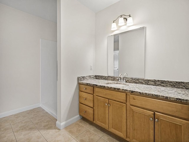 bathroom featuring baseboards, tile patterned floors, and vanity