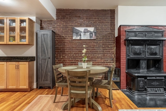 dining room featuring light hardwood / wood-style flooring and brick wall