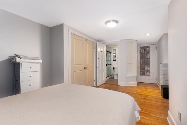 bedroom with wood-type flooring and ensuite bathroom