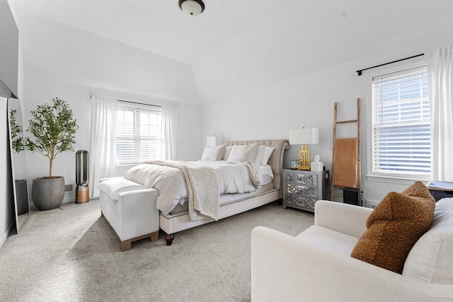 carpeted bedroom with vaulted ceiling and multiple windows