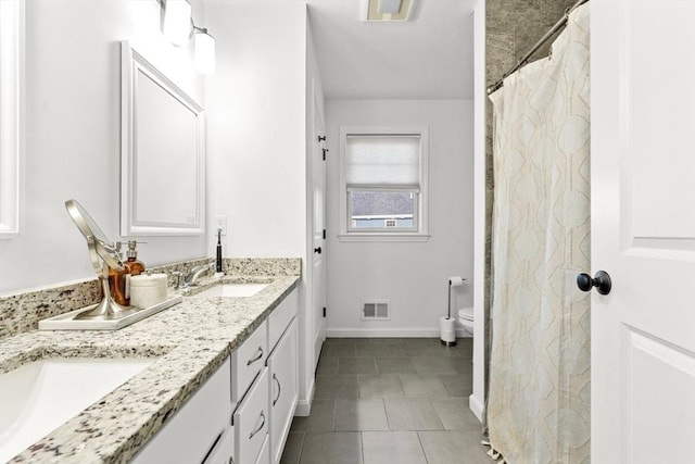 bathroom with tile patterned flooring, vanity, and toilet