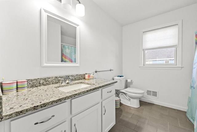 bathroom featuring tile patterned floors, vanity, and toilet