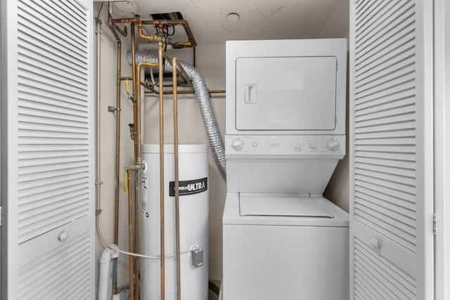 washroom featuring water heater and stacked washer and clothes dryer