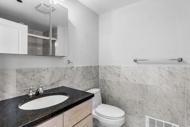 bathroom with vanity, toilet, and a shower with shower door