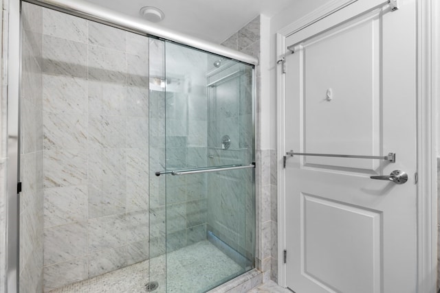 bathroom featuring a shower with door