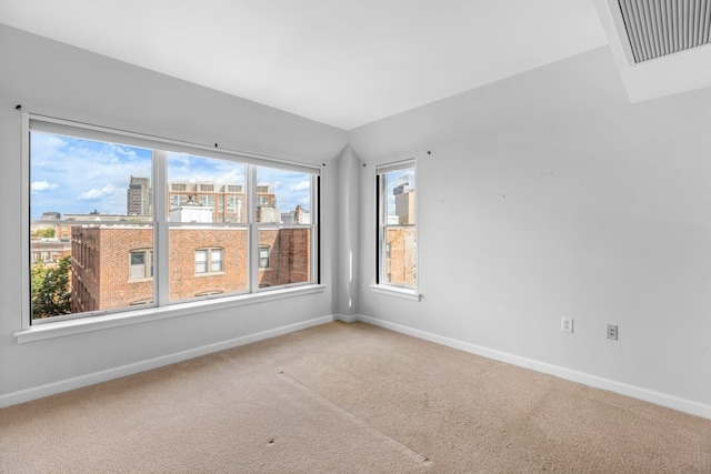 carpeted spare room with vaulted ceiling