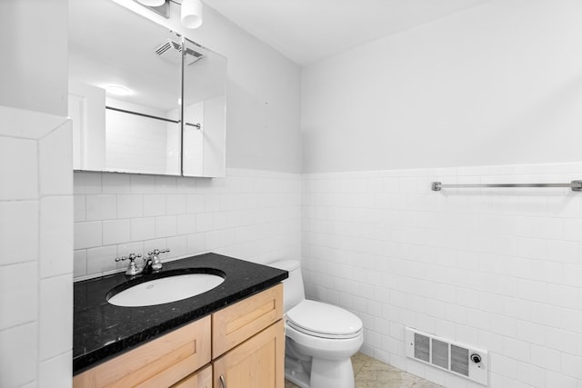 bathroom featuring vanity, toilet, tile walls, and tile patterned floors