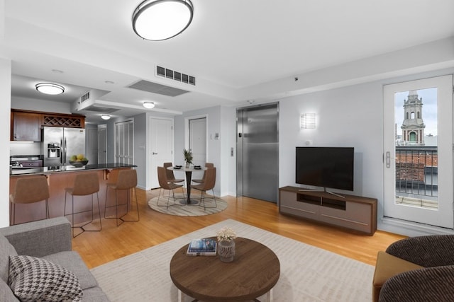 living room featuring light hardwood / wood-style floors and elevator