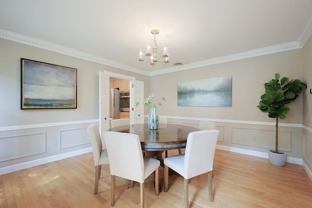 5 Taintor Dr, Sudbury, MA 01776 - dining space with a chandelier, light wood finished floors, ornamental molding, wainscoting, and a decorative wall