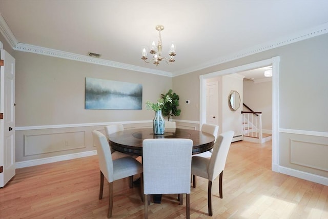 5 Taintor Dr, Sudbury, MA 01776 - dining room with light wood-style flooring, a chandelier, ornamental molding, stairs, and a wainscoted wall