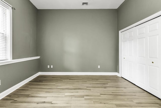 31-33 Ashland St Unit 3, Haverhill, MA 01830 - unfurnished bedroom featuring a closet, light wood-style floors, multiple windows, and baseboards