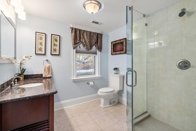 bathroom with vanity, a shower with shower door, tile patterned floors, and toilet