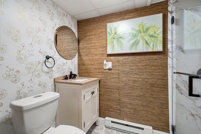 bathroom with vanity, a baseboard heating unit, a paneled ceiling, and toilet