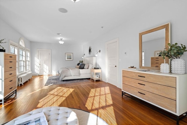 bedroom with radiator and dark wood finished floors