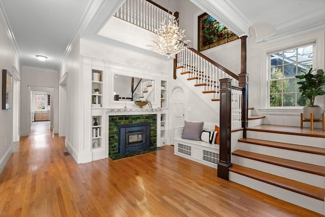 unfurnished living room with a chandelier, stairs, plenty of natural light, and wood finished floors