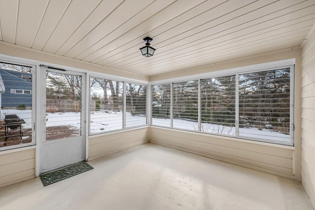 unfurnished sunroom with wood ceiling and a healthy amount of sunlight