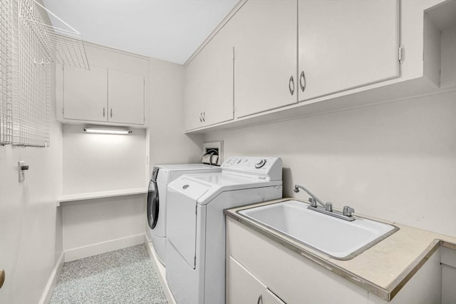 laundry room featuring baseboards, a sink, cabinet space, and washer and dryer