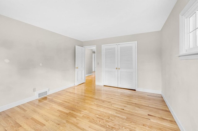 unfurnished bedroom featuring baseboards, visible vents, and light wood-style floors