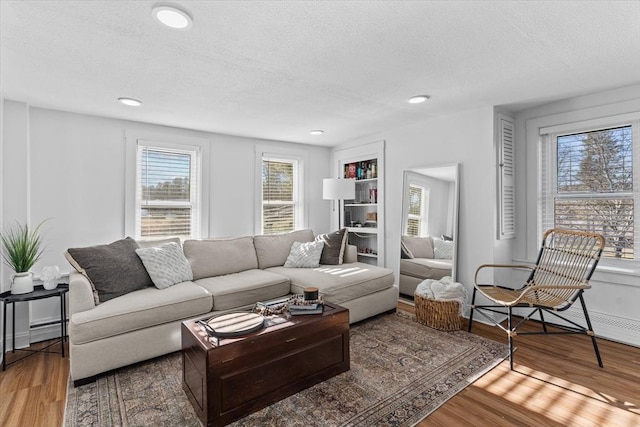 living room featuring wood-type flooring and a textured ceiling