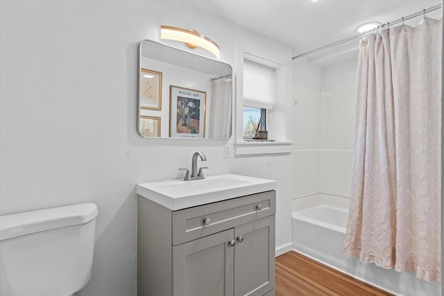 full bathroom featuring vanity, hardwood / wood-style flooring, toilet, and shower / bathtub combination with curtain