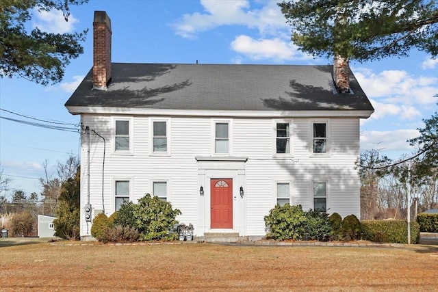 colonial inspired home with a front lawn