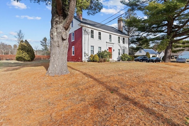 colonial inspired home featuring a front lawn