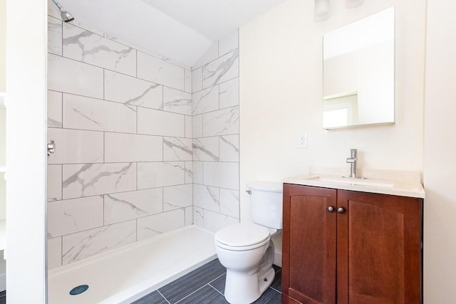 bathroom with toilet, a stall shower, and vanity