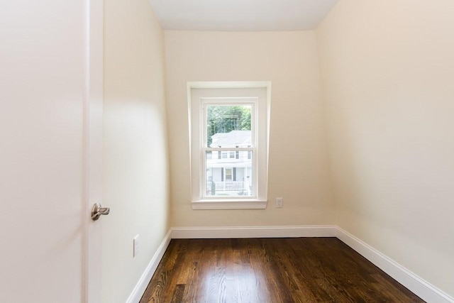 empty room with dark wood-type flooring and baseboards