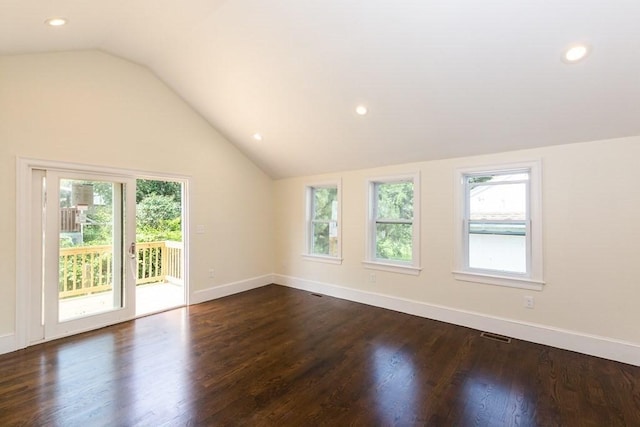 unfurnished room featuring a healthy amount of sunlight, dark wood-style floors, and lofted ceiling