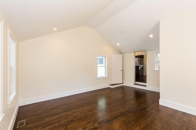 unfurnished living room with lofted ceiling, baseboards, and wood finished floors