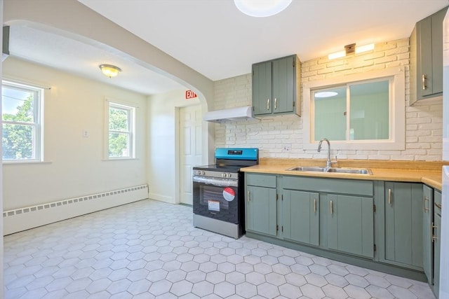 318 Newton St, South Hadley, MA 01075 - kitchen with stainless steel electric range oven, baseboard heating, under cabinet range hood, a sink, and light countertops