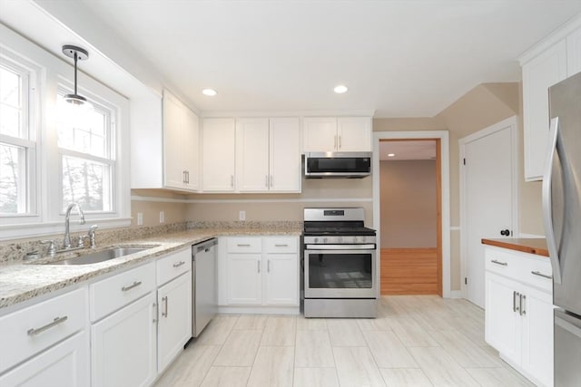 kitchen featuring light stone counters, recessed lighting, a sink, white cabinets, and appliances with stainless steel finishes