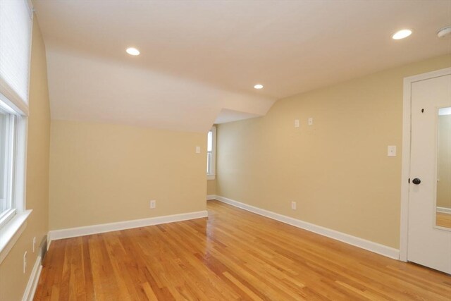 unfurnished room featuring recessed lighting, light wood-style flooring, baseboards, and vaulted ceiling