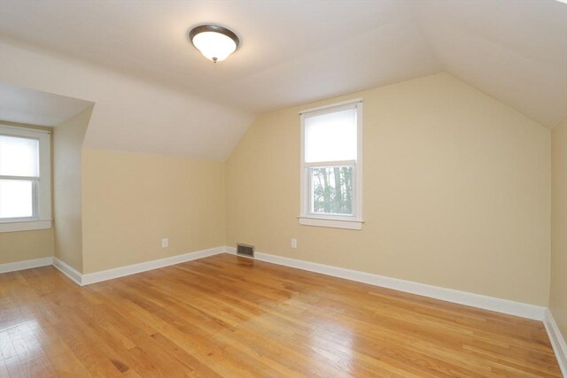 bonus room with light wood-style flooring, visible vents, baseboards, and a wealth of natural light