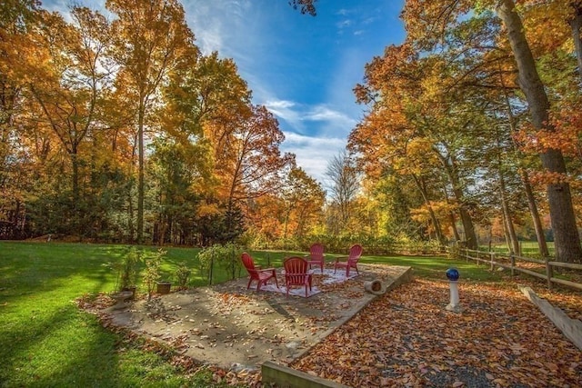 view of property's community with a patio, a lawn, and fence