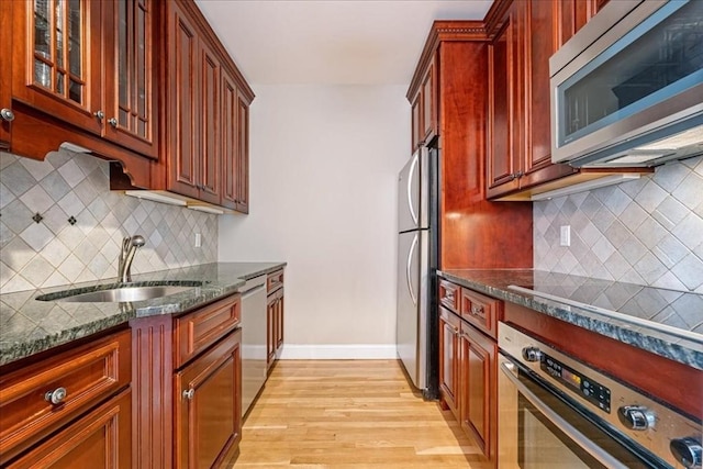 130 Appleton St Unit 4E, Boston, MA 02116 - kitchen featuring appliances with stainless steel finishes, a sink, light wood-type flooring, dark stone counters, and decorative backsplash