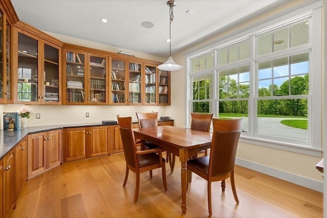 dining room with light wood finished floors, baseboards, and recessed lighting