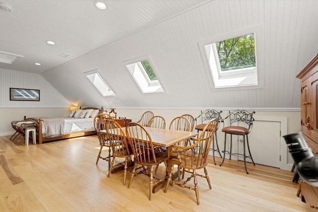 dining area with light wood finished floors, vaulted ceiling with skylight, and recessed lighting