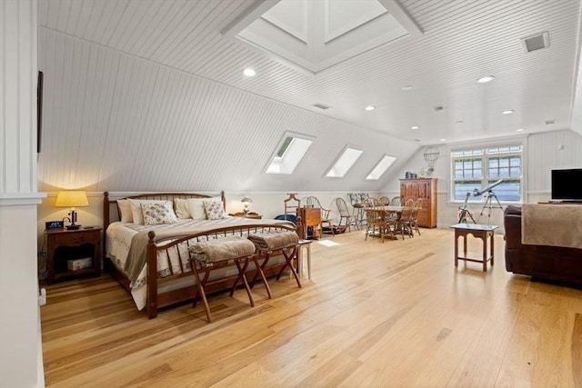 bedroom with light wood-type flooring and vaulted ceiling with skylight